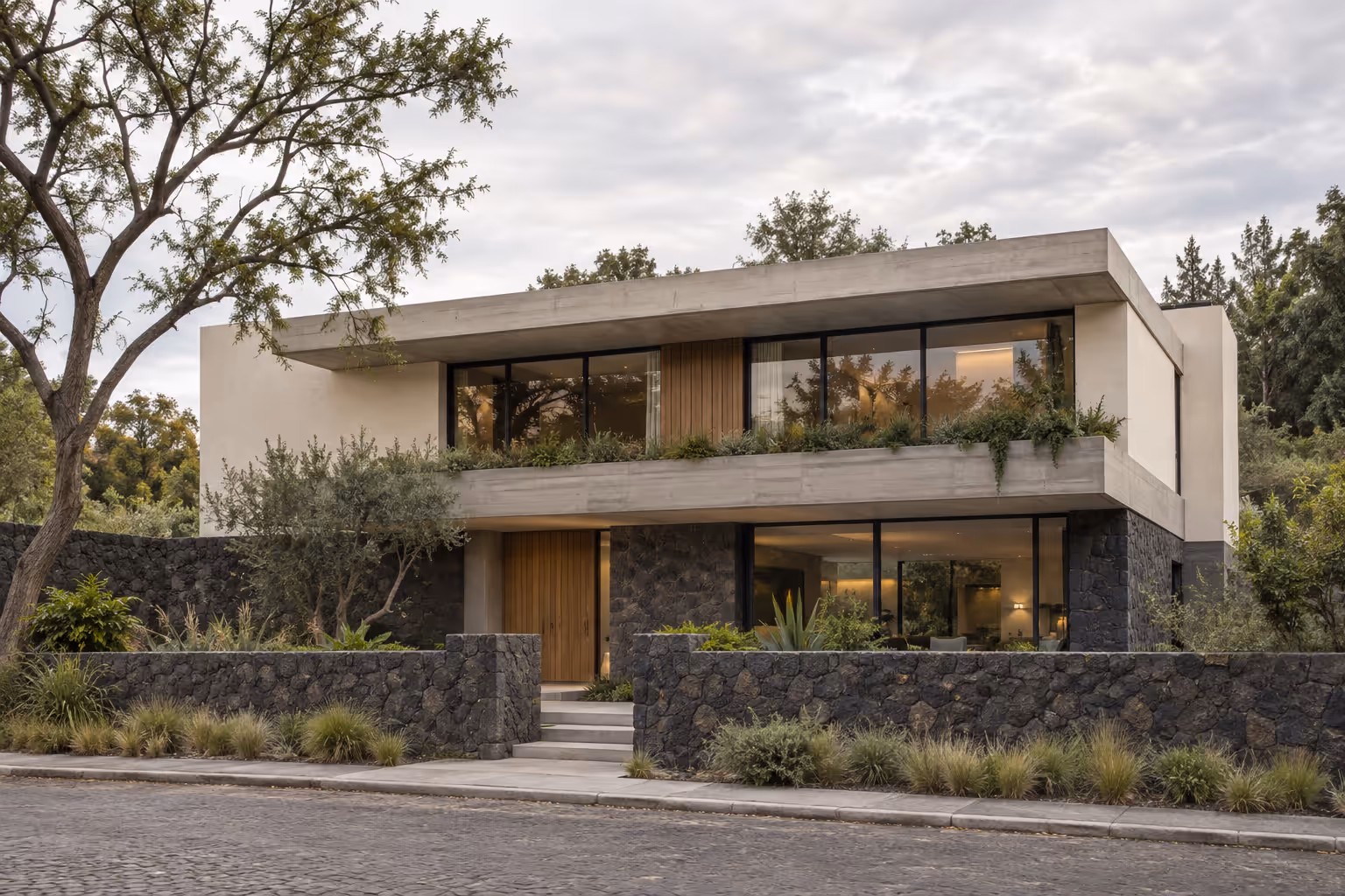 Concepto de la misma residencia terminada con concreto, piedra volcánica y vegetación
